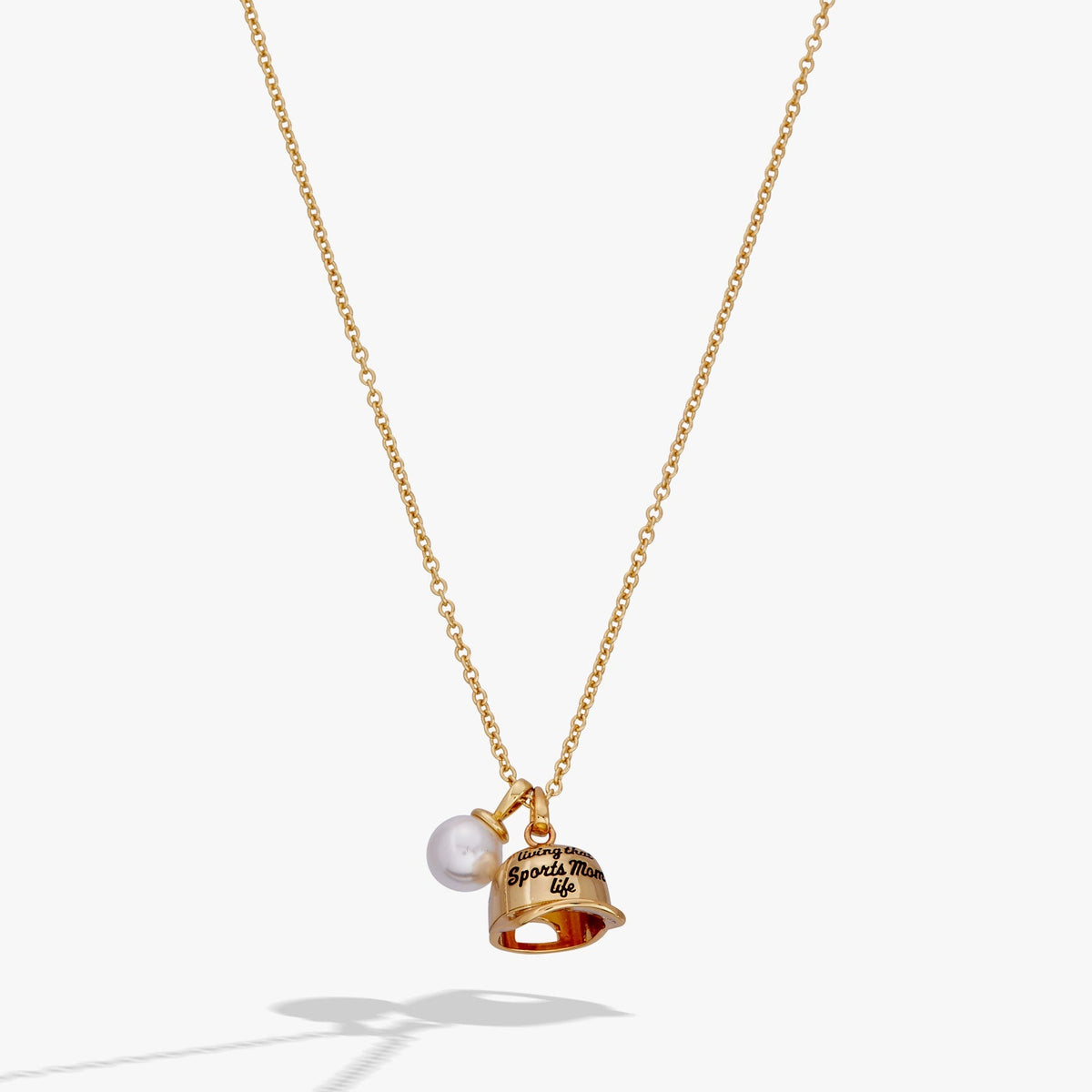 Gold necklace with a bell and pearl pendant on a white background