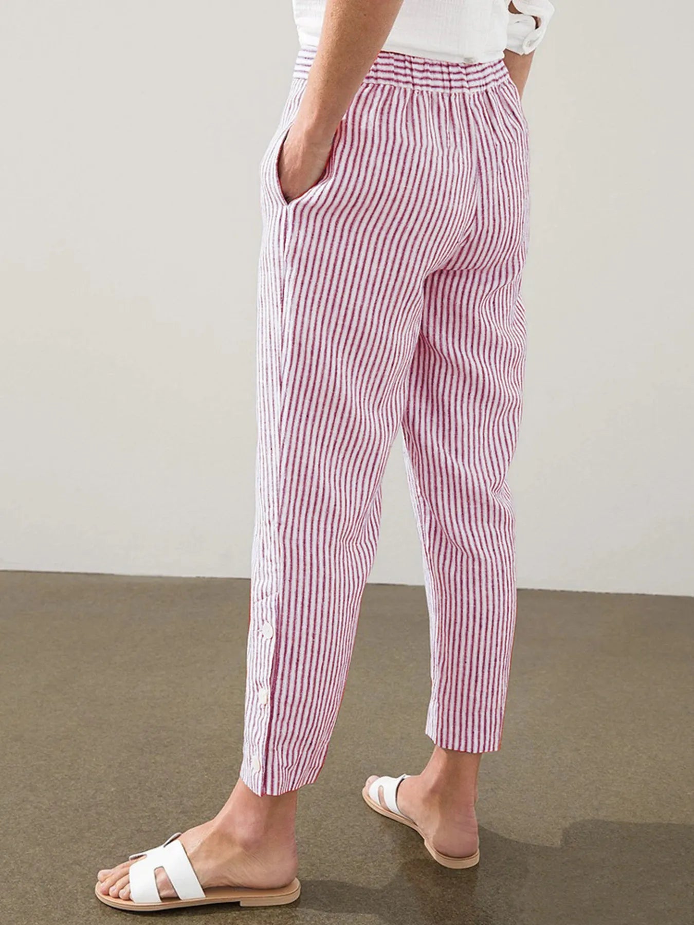 Back view of Madison Striped Button-Hem Pants in red, featuring elastic waistband and tapered leg. Comfortable and stylish resort wear.