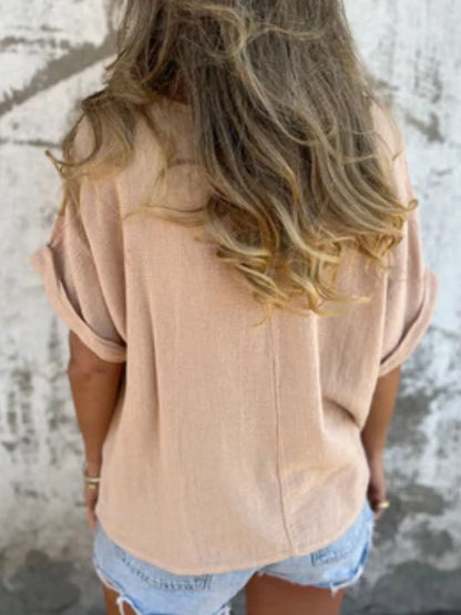Back view of beige Women's Oversized Essential Tee highlighting its flowy fit and casual style, paired with shorts.