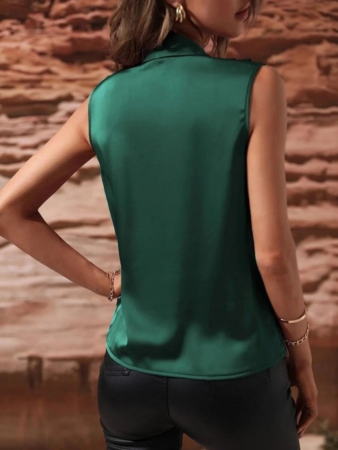 Back view of emerald green Satin Draped Blouse showing smooth satin finish and sleeveless cut for a sleek silhouette.