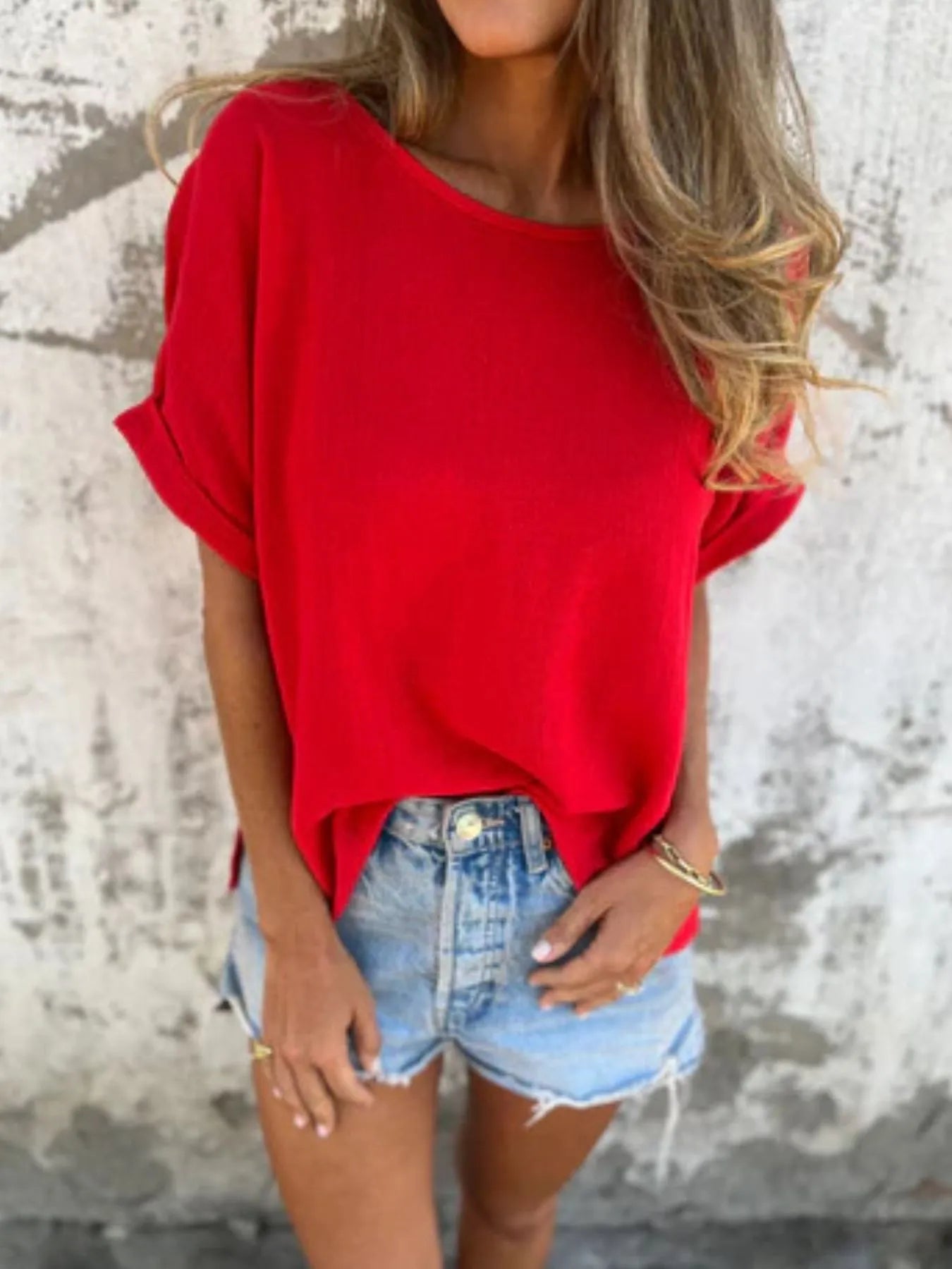 Red Women's Oversized Essential Tee styled with cuffed sleeves and tucked into high-waisted denim shorts for a bold casual outfit.