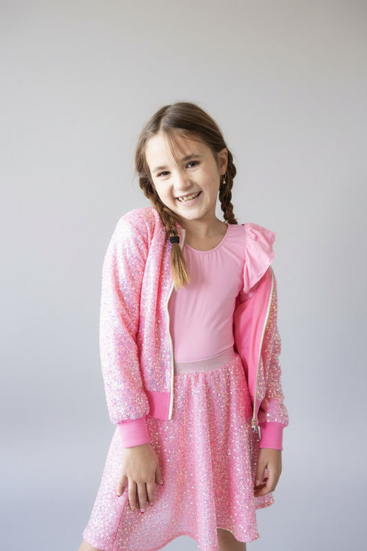 Young girl wearing a pink outfit with a hood on a white background