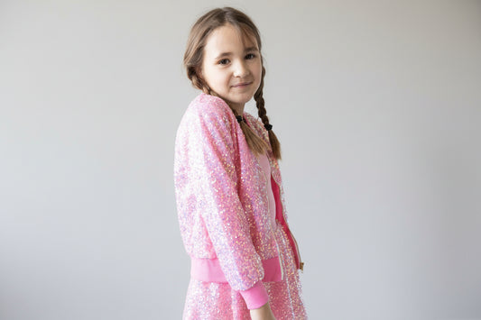 Young girl wearing a pink sequin outfit on a white background