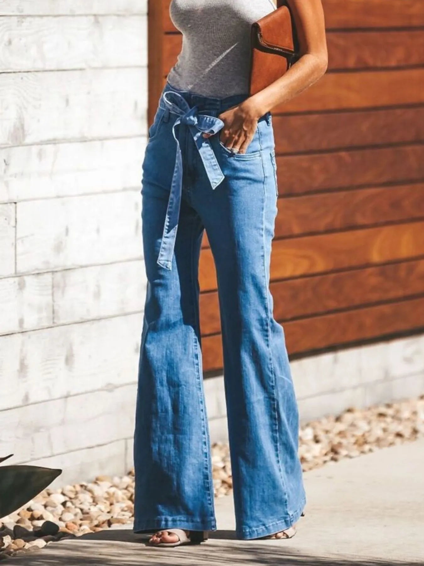 High-waisted Women's Tie-Front Flare Jeans with front tie detail and stretch fit, styled for a chic daytime look.