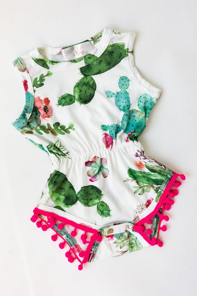 Children's outfit with cactus design and pink pom-pom trim on a white background