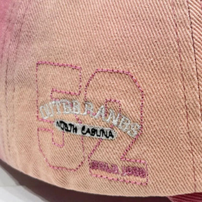 Detailed embroidery on side of pink Living the Dream Gradient Denim Baseball Cap with 'Outer Banks 52 North Carolina' text.