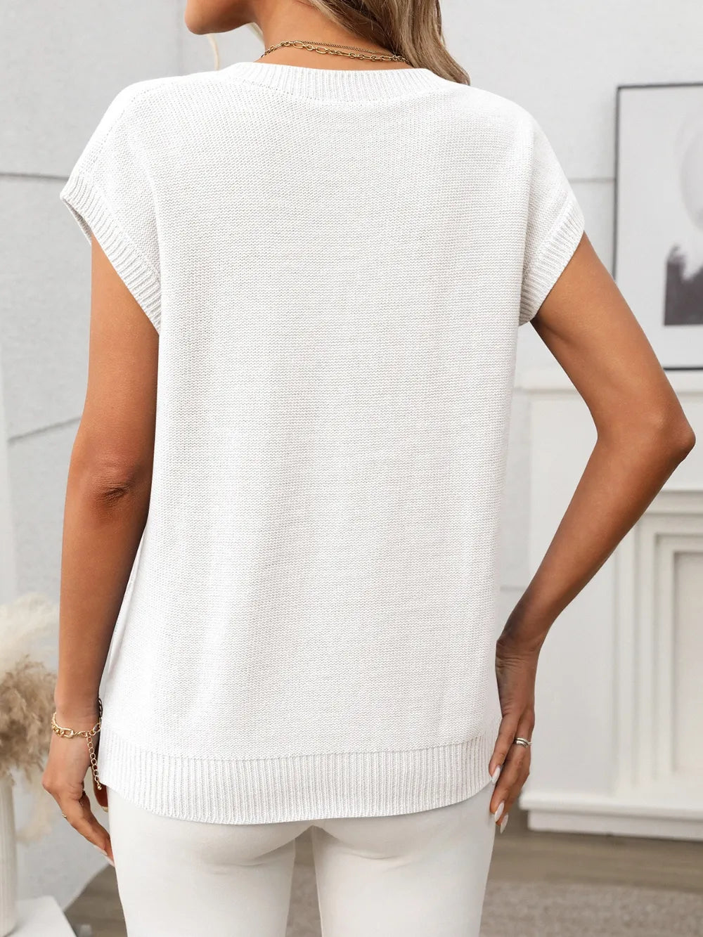 Back view of white Cable-Knit V-Neck Top showing smooth knit texture and ribbed hem for a polished finish.
