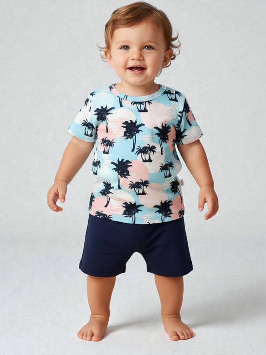 Child wearing a colorful palm tree shirt and navy shorts on a plain background